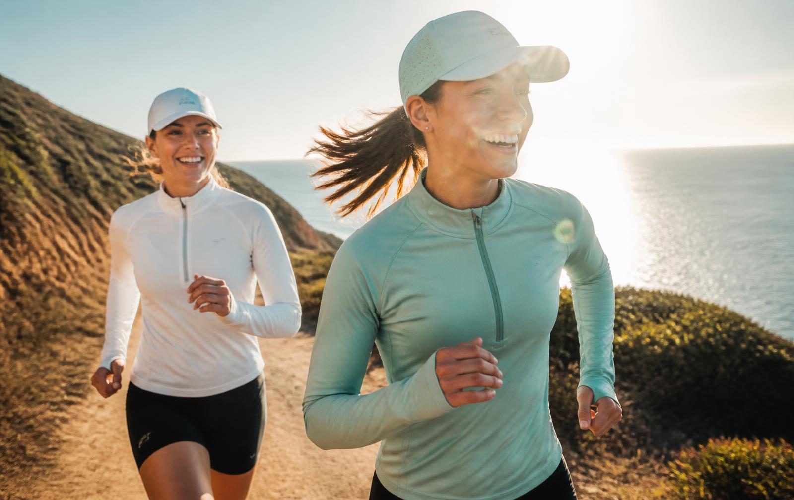 Runners on a coastal trail wearing UPF 50+ long sleeve tops in bright sun